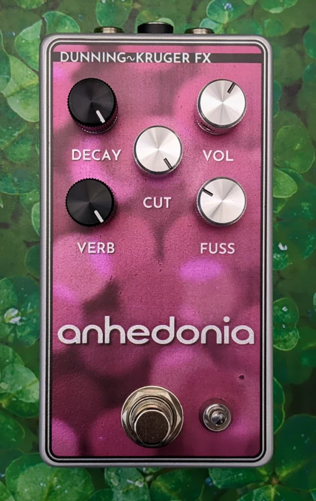 Anhedonia Pedal in blurry burgundy color with silver writing, labeled Decay, Verb, Cut, Vol, and Fuss